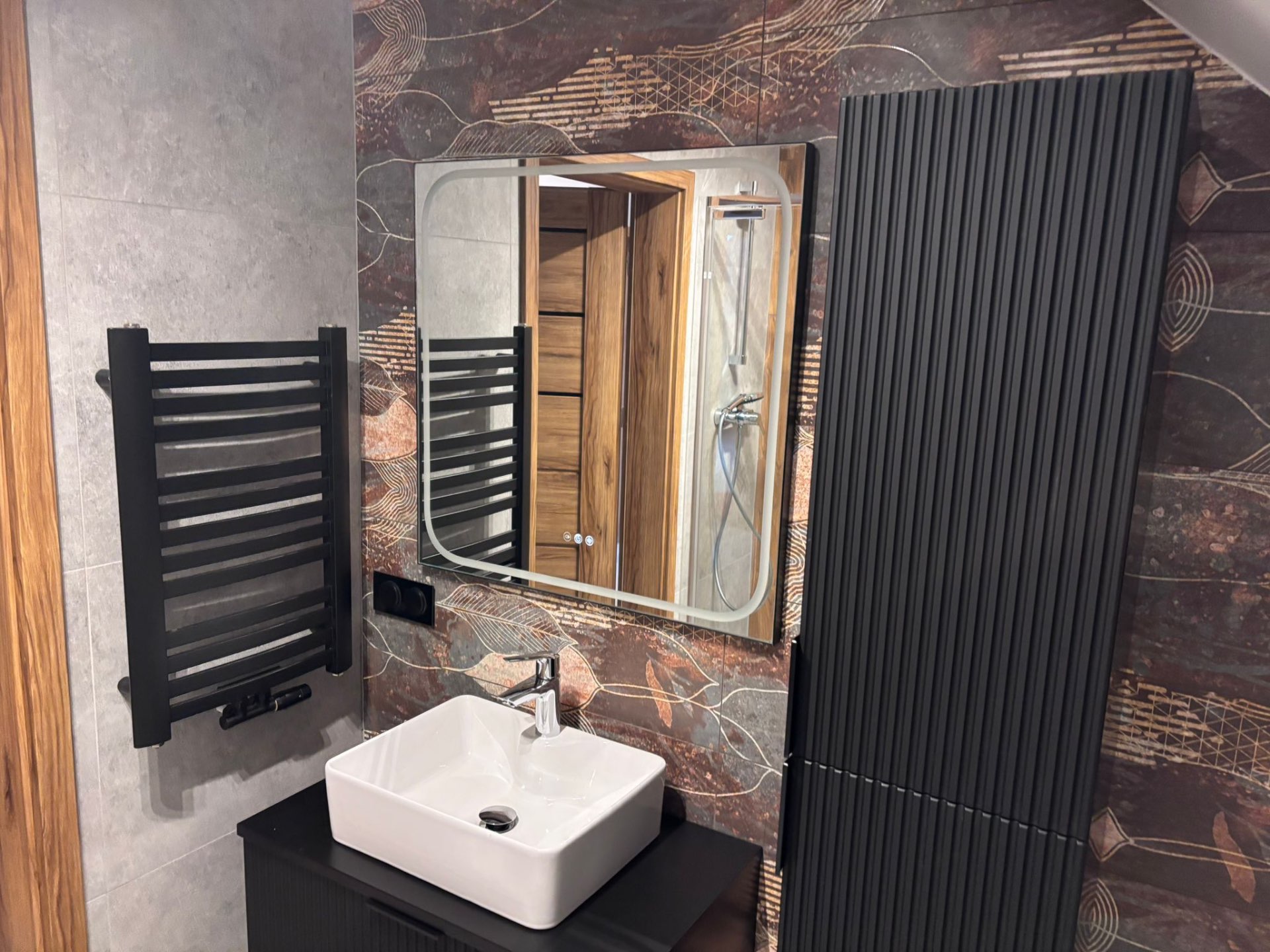 Łazienka z designerską tapetą i czarną armaturą